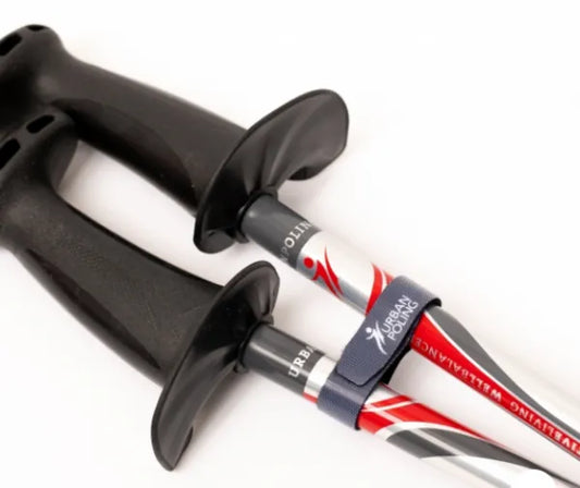 Close-up of a black-handled hiking pole with a visible brand logo on a white background