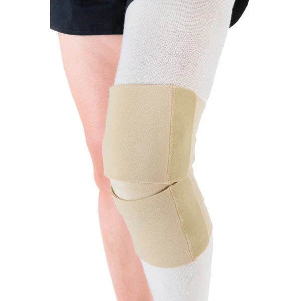 A beige knee immobilizer brace worn on a person's knee, paired with white compression socks, shown against a plain white background.