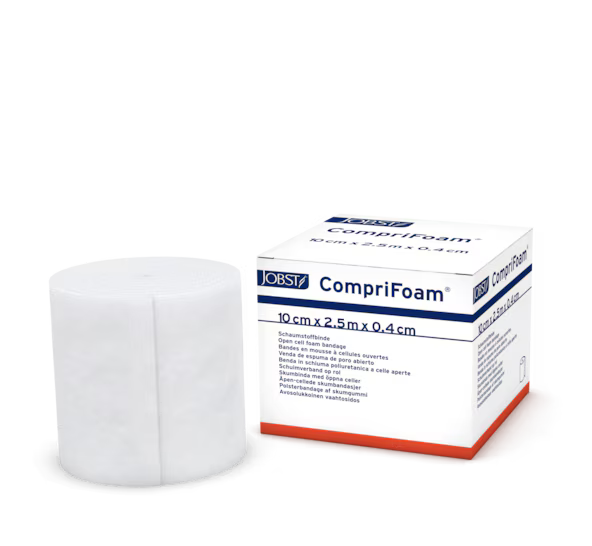 A white roll of CompriFoam medical dressing material stands beside its retail box on a clean white background. The box is labeled JOBST and CompriFoam with dimensions 10 cm x 2.