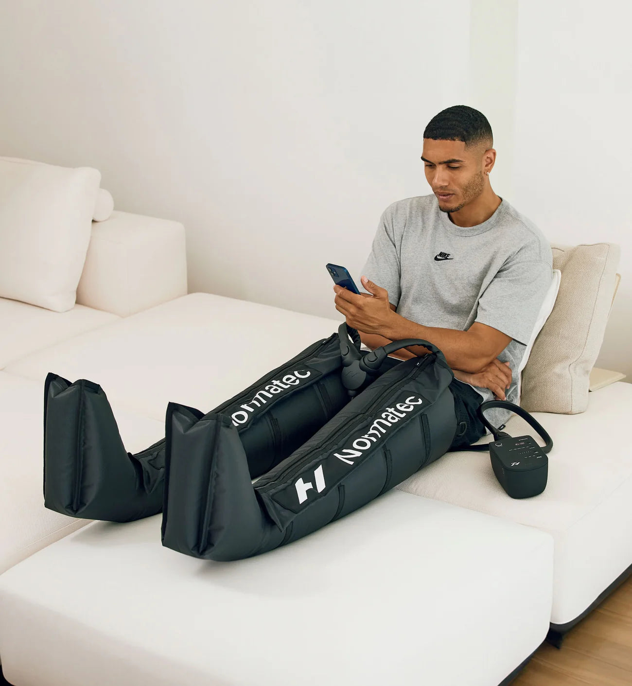 Guy sitting with Normatec 3 on his legs